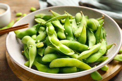 Green edamame beans in pods served on wooden table, closeup