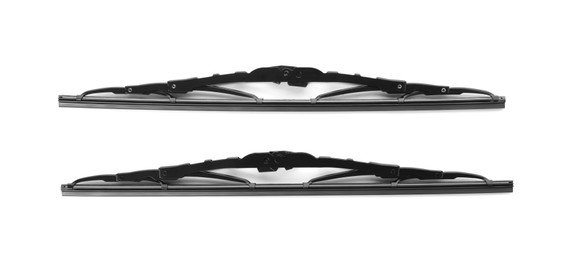 Pair of car windshield wipers on white background, top view