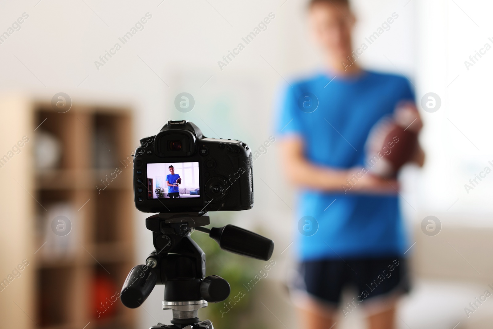 Photo of Sports blogger recording fitness lesson at home, focus on camera. Space for text