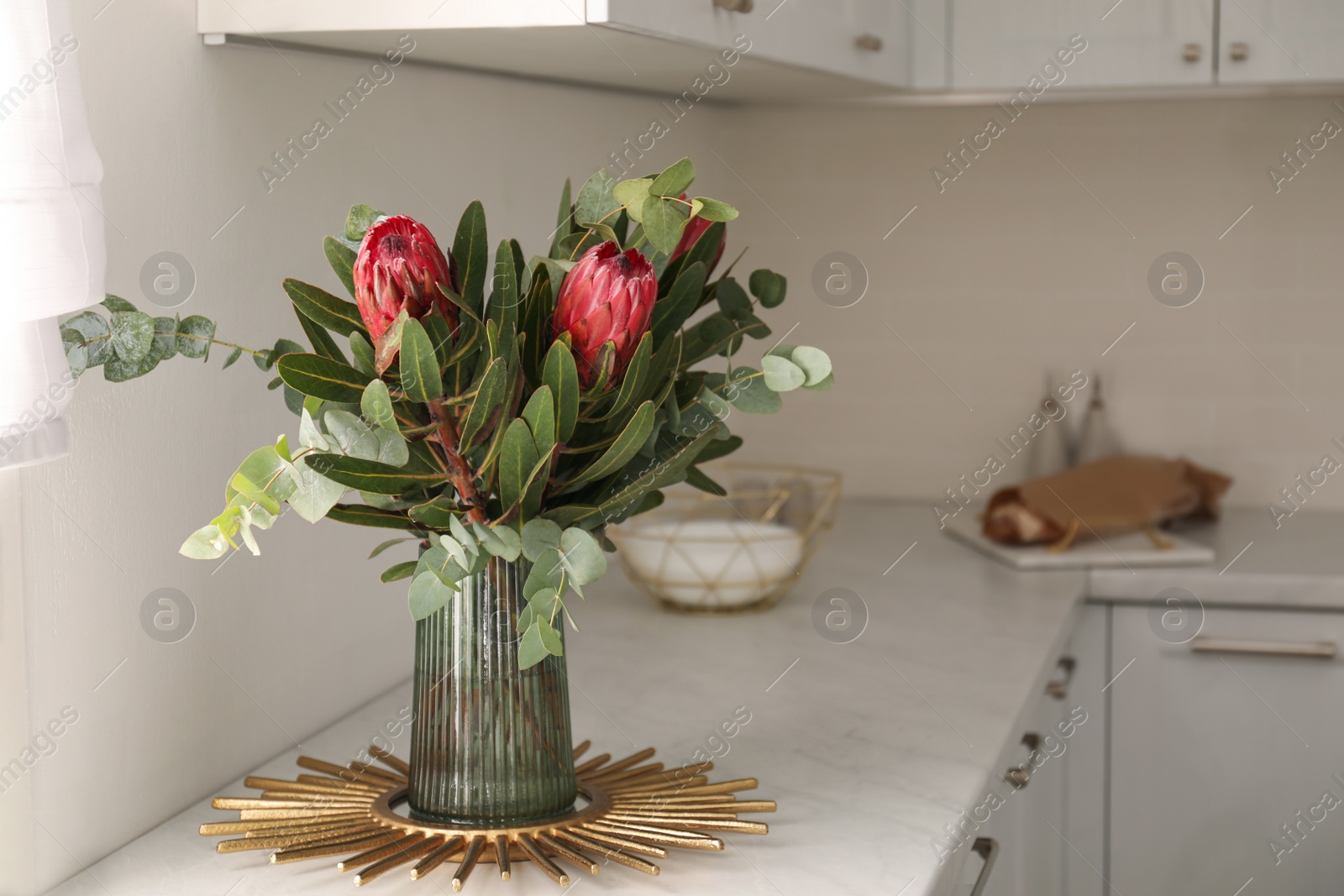 Photo of Bouquet with beautiful protea flowers on countertop in kitchen, space for text. Interior design