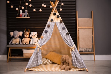 Photo of Cozy kids room interior with play tent and toys