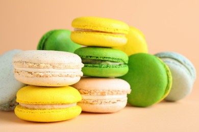 Photo of Delicious fresh colorful macarons on beige background, closeup