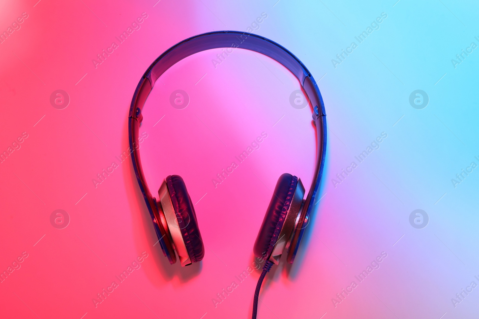 Photo of Stylish headphones on color background, top view