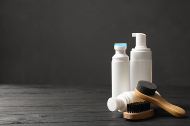 Composition with shoe care accessories on black wooden table. Space for text