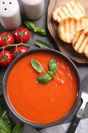 Photo of Flat lay composition with delicious tomato cream soup in bowl on grey table