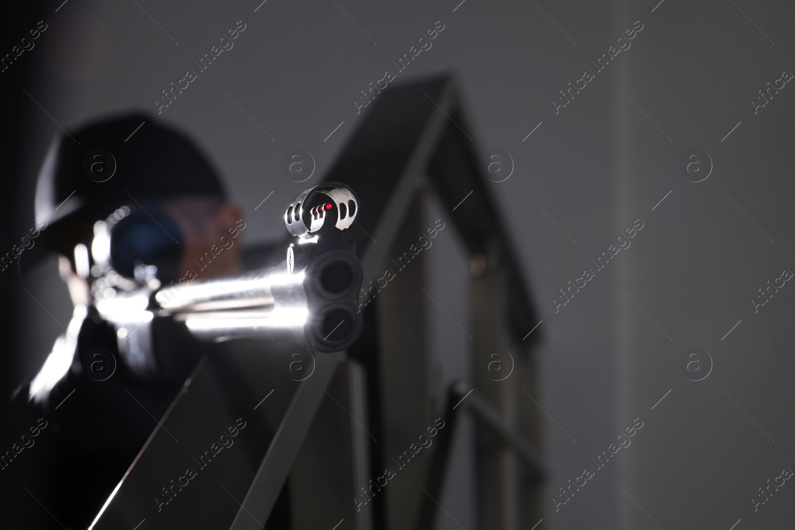 Photo of Hired professional killer indoors, focus on sniper rifle. Space for text