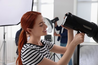 Photo of Young professional photographers working in modern photo studio