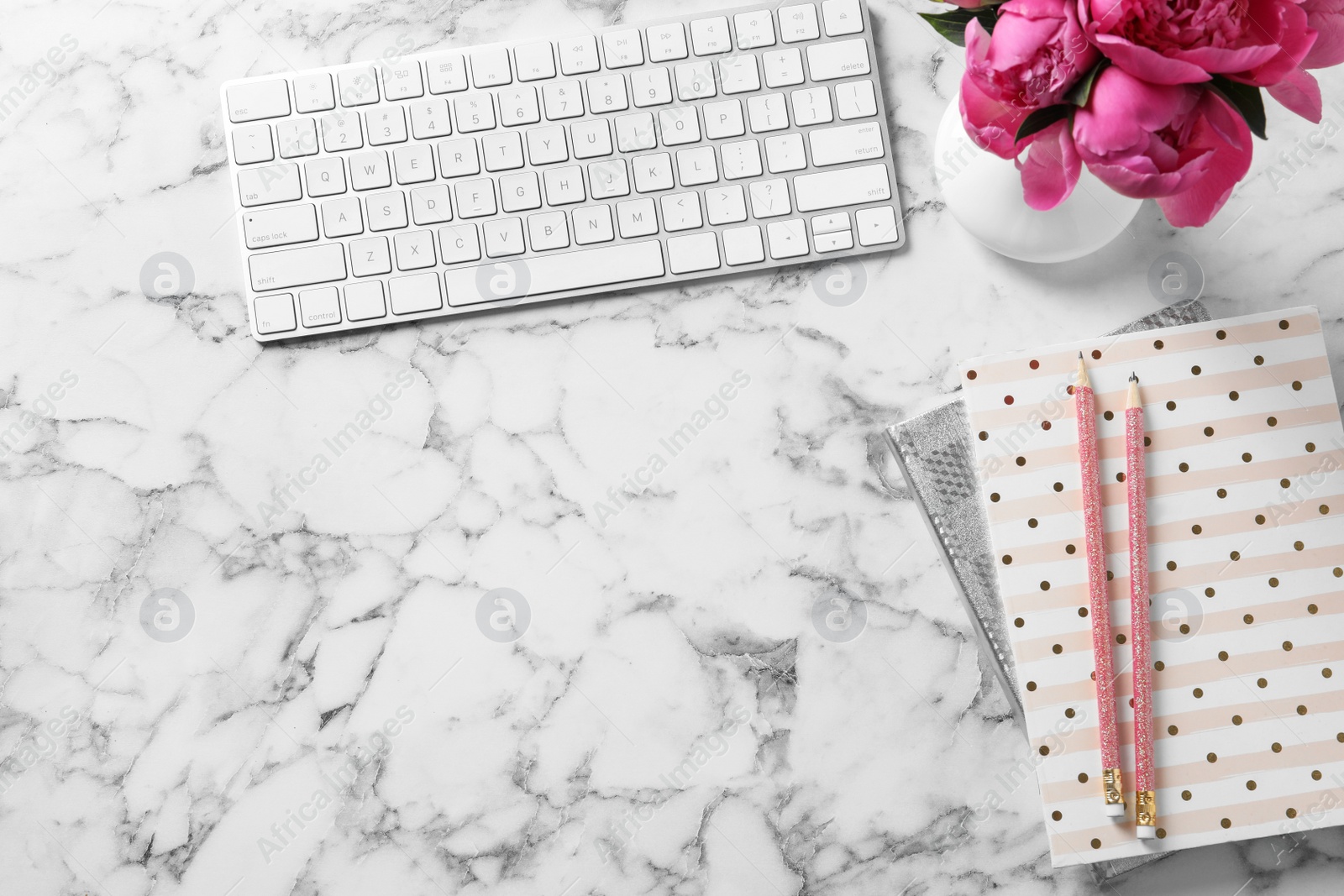 Photo of Stylish workplace with fragrant peonies on marble table, flat lay. Space for text