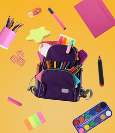 Backpack surrounded by flying school stationery on yellow background