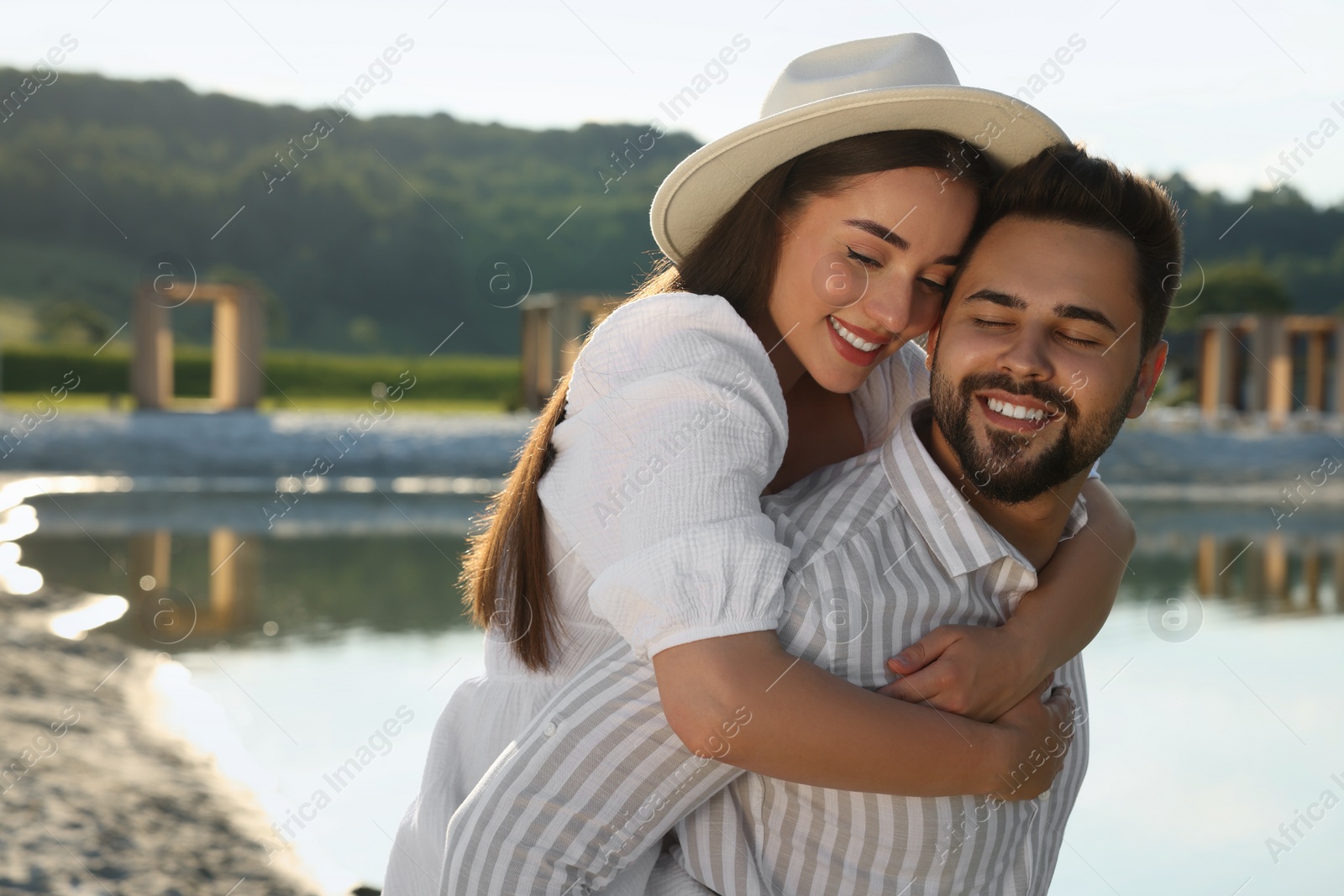 Photo of Romantic date. Beautiful couple spending time together near lake