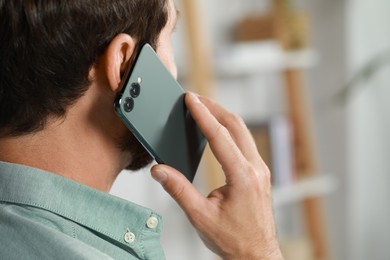 Photo of Man talking on phone at home, closeup. Space for text