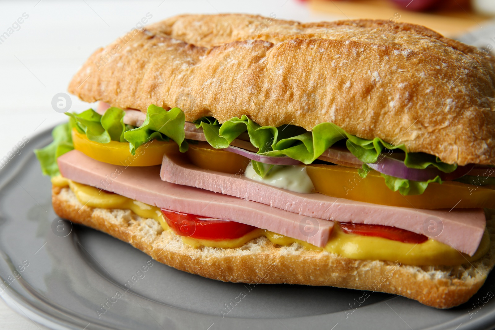 Photo of Tasty sandwich with boiled sausage, cheese and vegetables on table, closeup