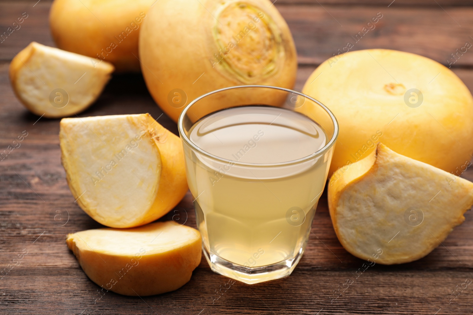 Photo of Glass of freshly made turnip juice on wooden table