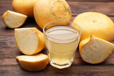 Photo of Glass of freshly made turnip juice on wooden table