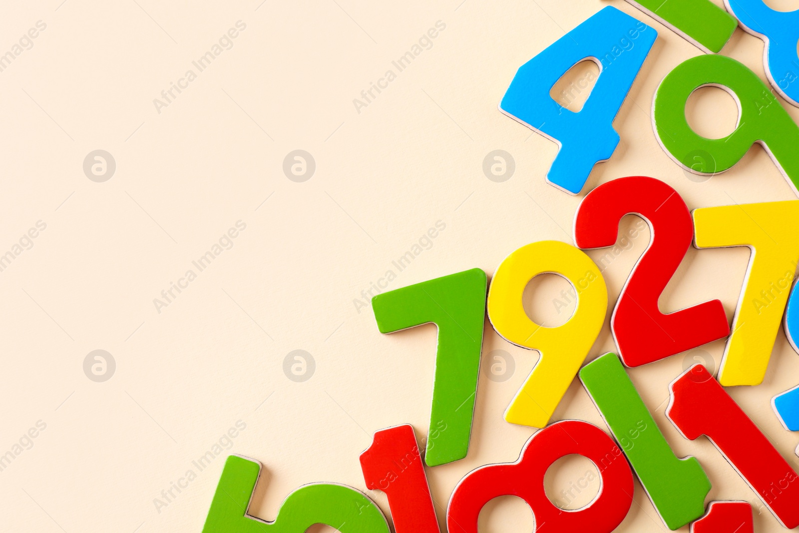 Photo of Colorful numbers on beige background, flat lay. Space for text