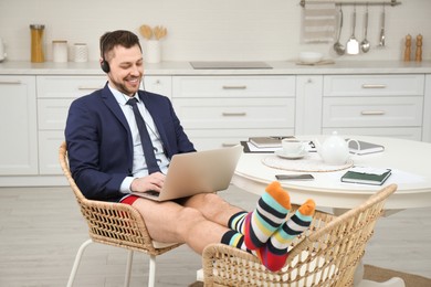 Businessman in underwear pretending to wear formal clothes during video call at home