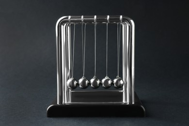 Photo of Newton's cradle on dark background. Physics law of energy conservation