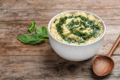 Photo of Bowl with tasty mashed potato on wooden table