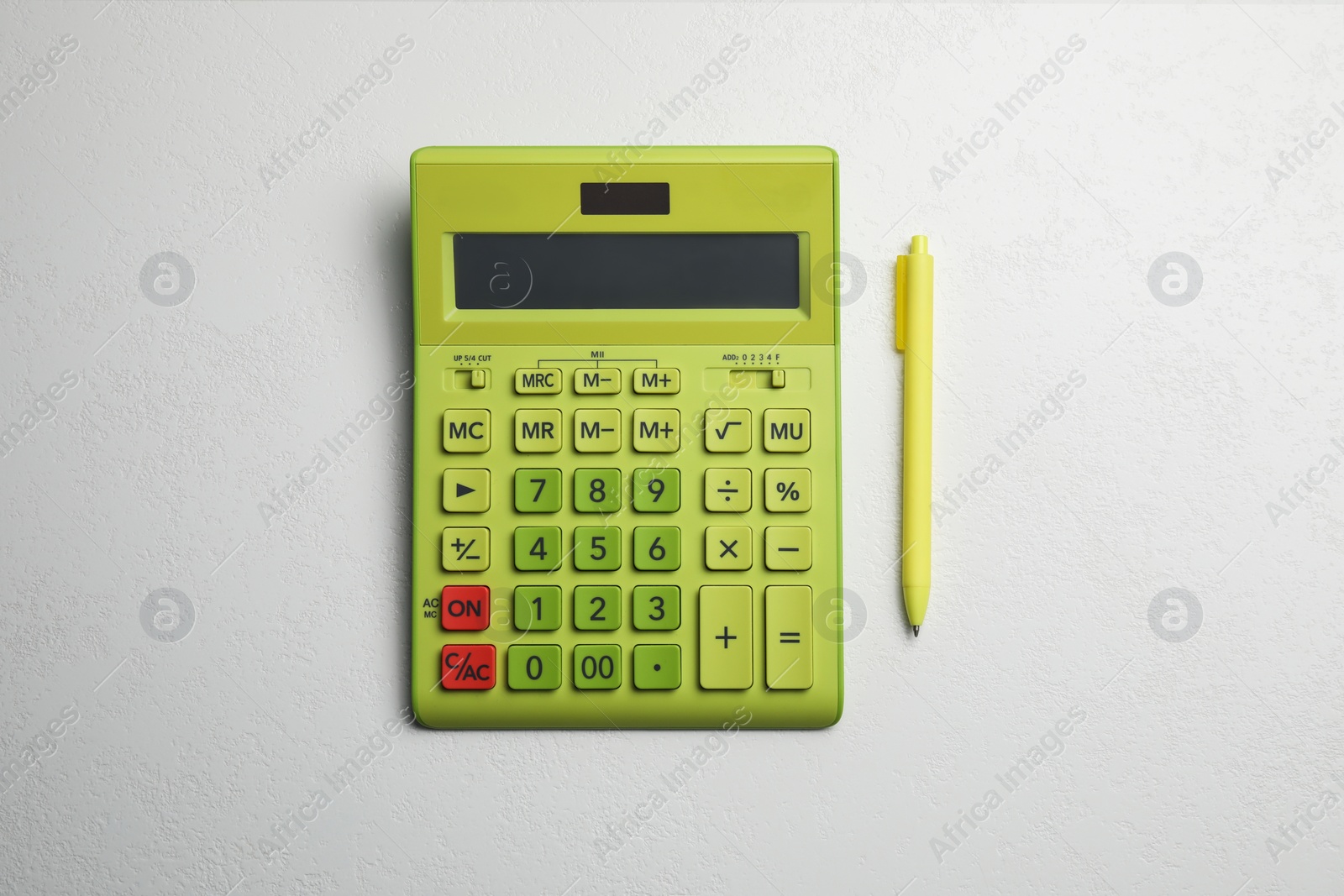 Photo of Calculator and pen on white table, top view