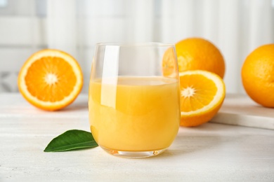 Photo of Glass with orange juice and fresh fruit on table