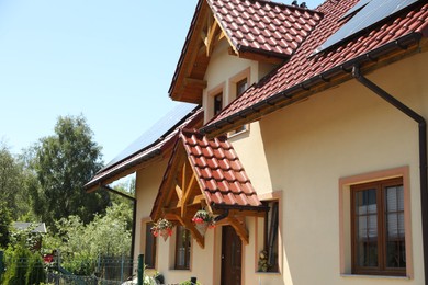 Exterior of beautiful house with red roof on sunny day