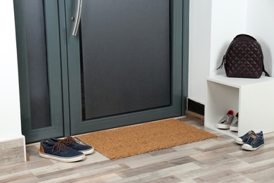 Photo of Hallway interior with shoes, backpack and mat near door