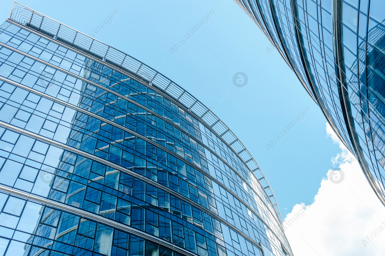 Photo of Stylish buildings with many windows under cloudy sky, low angle view