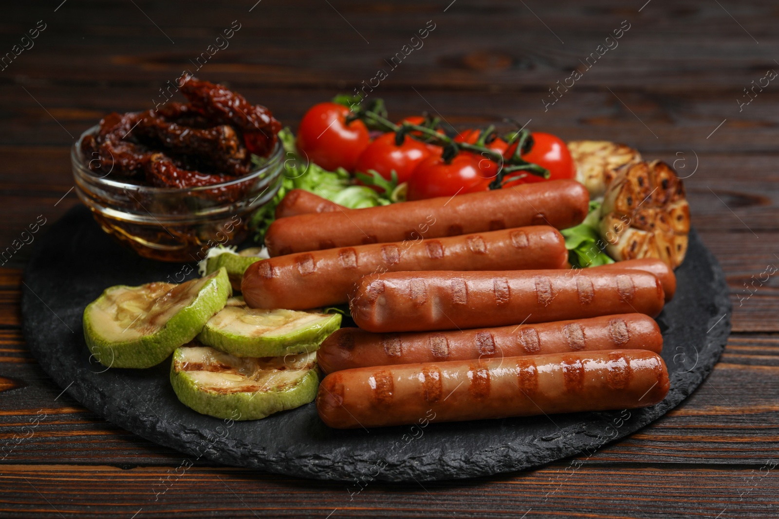 Photo of Delicious grilled sausages served on wooden table