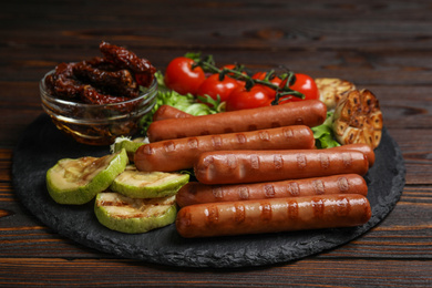 Delicious grilled sausages served on wooden table