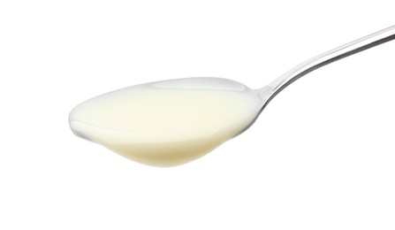 Metal spoon with condensed milk isolated on white