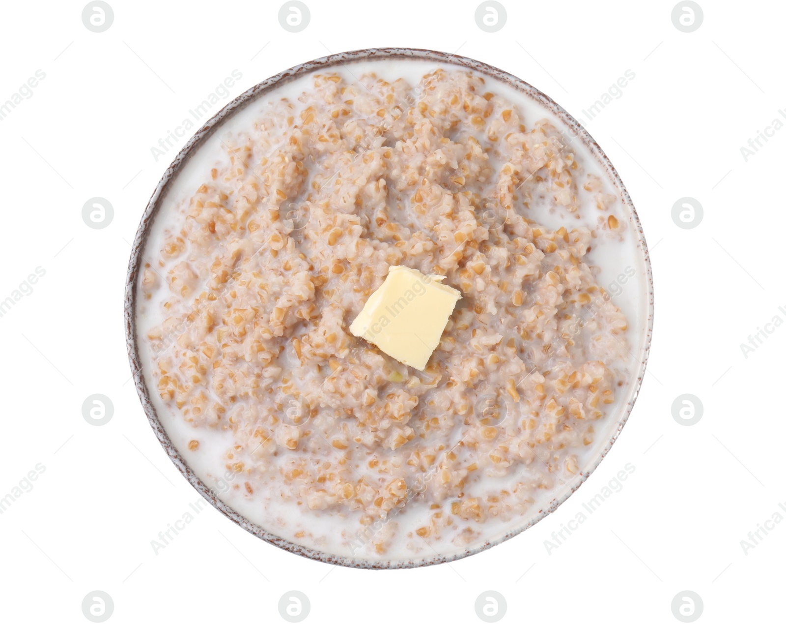 Photo of Tasty wheat porridge with milk and butter in bowl isolated on white, top view