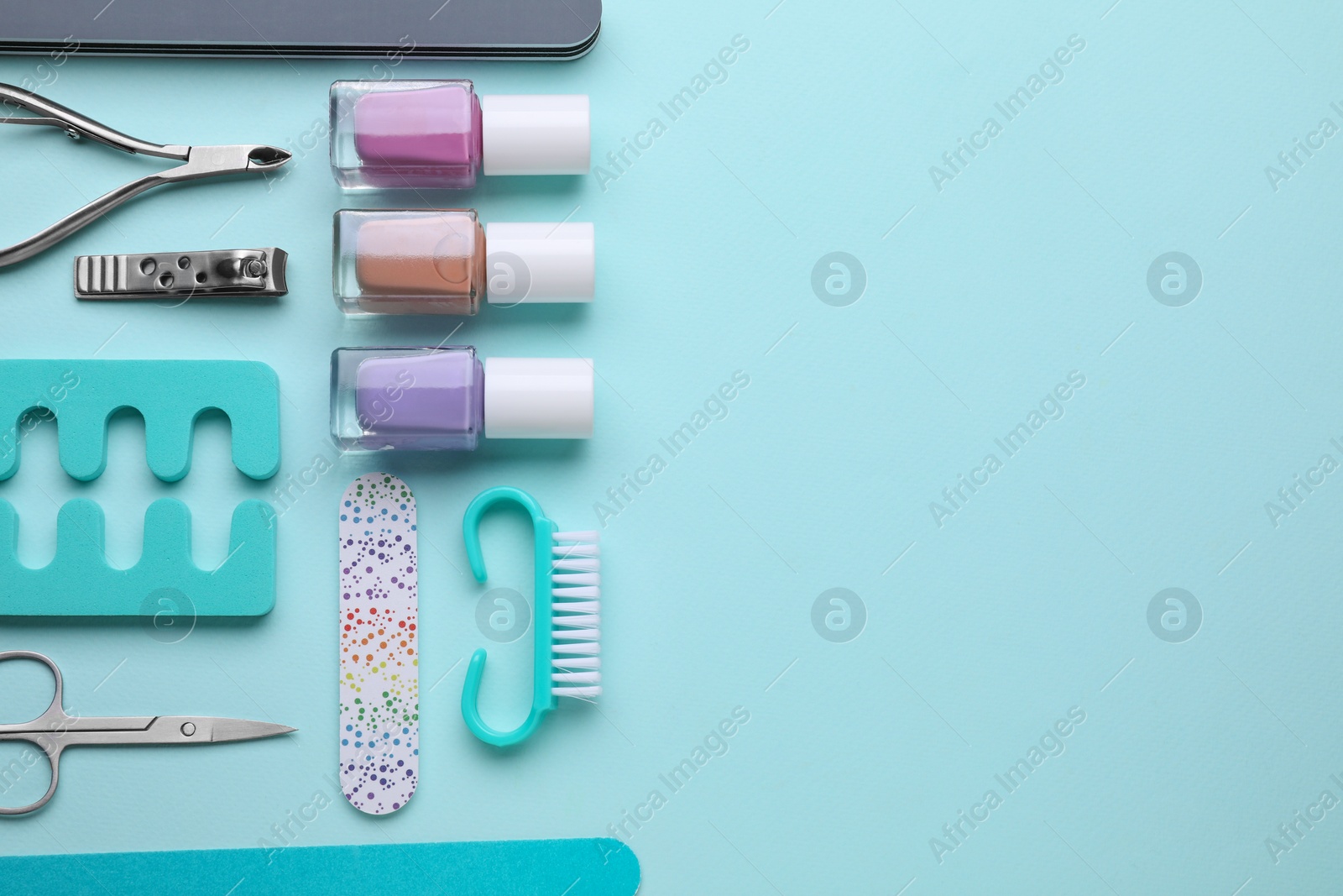 Photo of Set of pedicure tools on light blue background, flat lay. Space for text