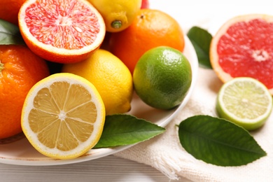 Photo of Different citrus fruits on white wooden table, closeup