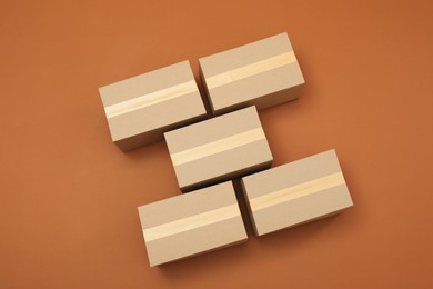 Photo of Many cardboard boxes on brown background, flat lay