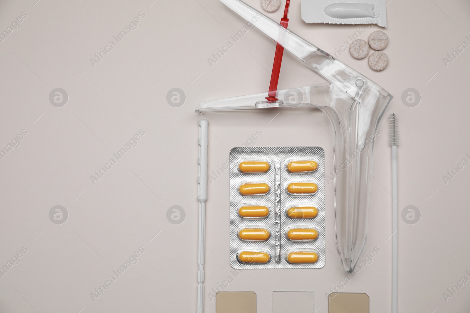 Photo of Sterile gynecological examination kit and medicaments on beige background, flat lay. Space for text