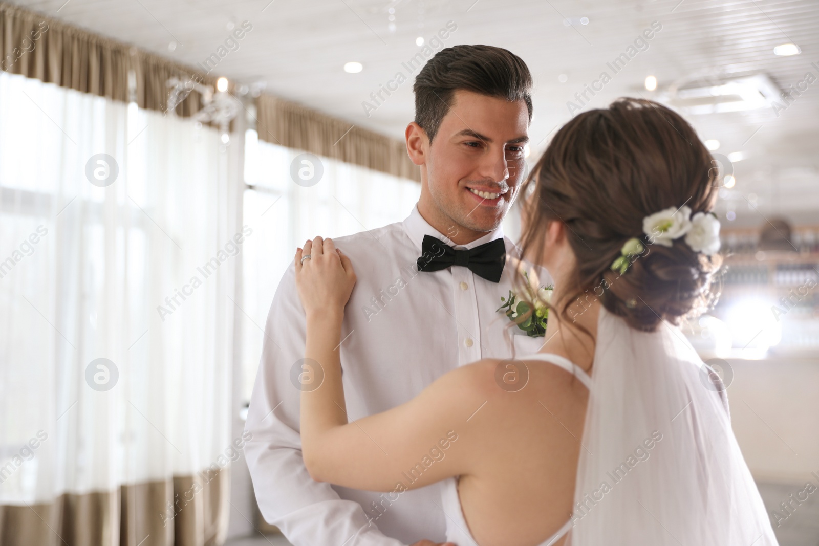 Photo of Happy newlywed couple dancing together in festive hall