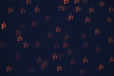 Photo of Blurred view of note shaped lights on dark background. Bokeh effect