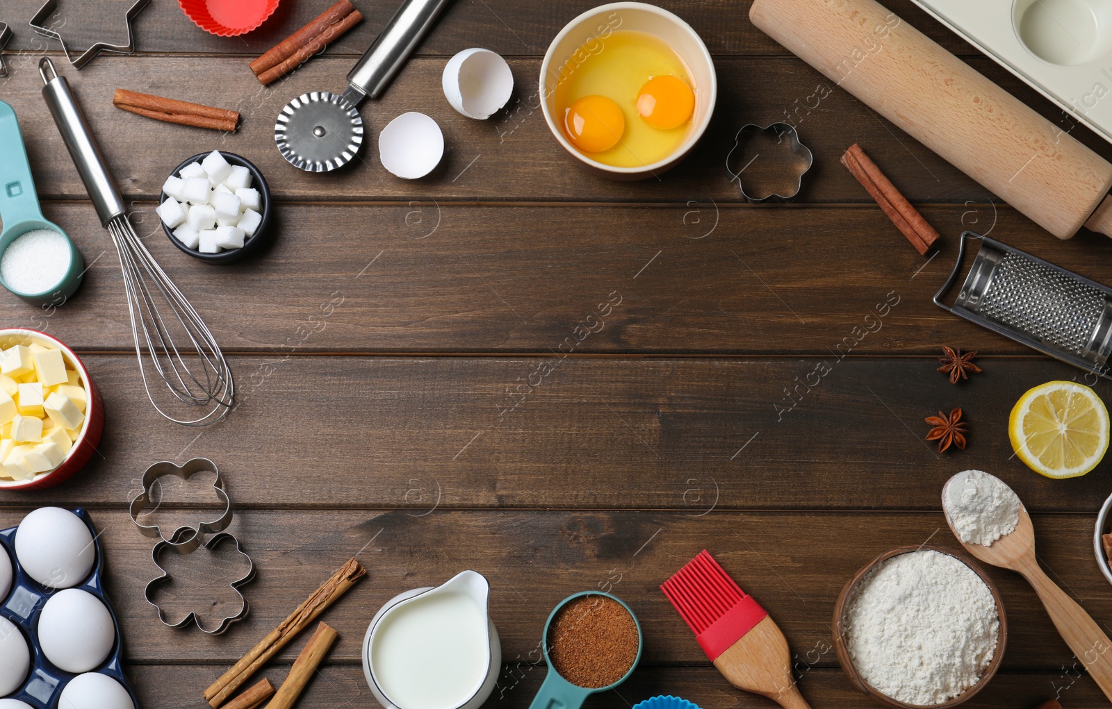 Photo of Frame of cooking utensils and ingredients on wooden table, flat lay. Space for text