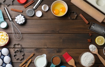 Frame of cooking utensils and ingredients on wooden table, flat lay. Space for text