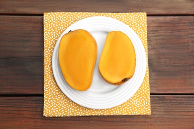Photo of Delicious cut ripe mangos on wooden table, top view