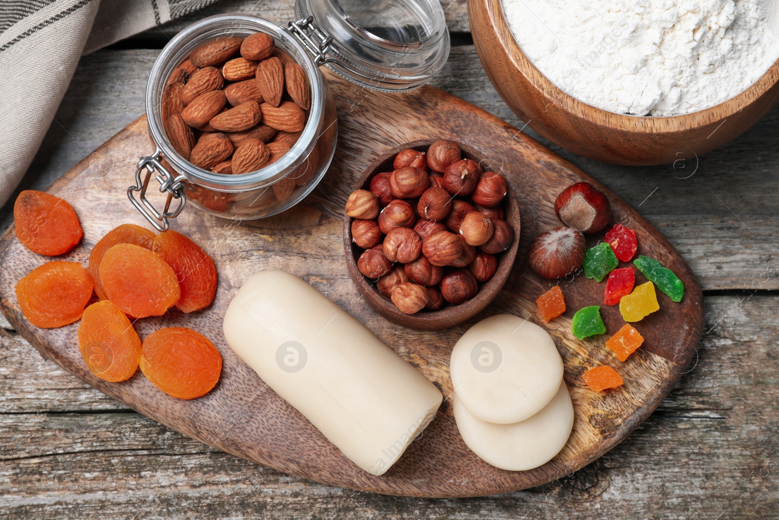 Photo of Marzipan and other ingredients for homemade Stollen on wooden table, flat lay. Baking traditional German Christmas bread