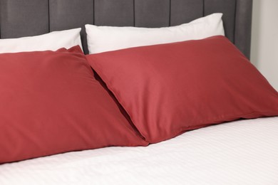 Photo of Soft pillows and striped bedsheet on bed