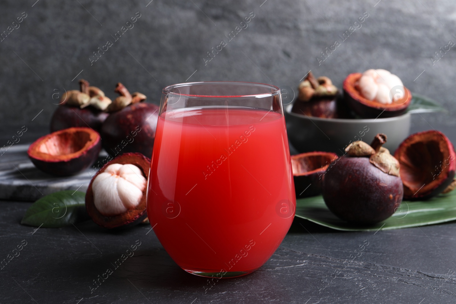 Photo of Delicious mangosteen juice and fresh fruits on dark table