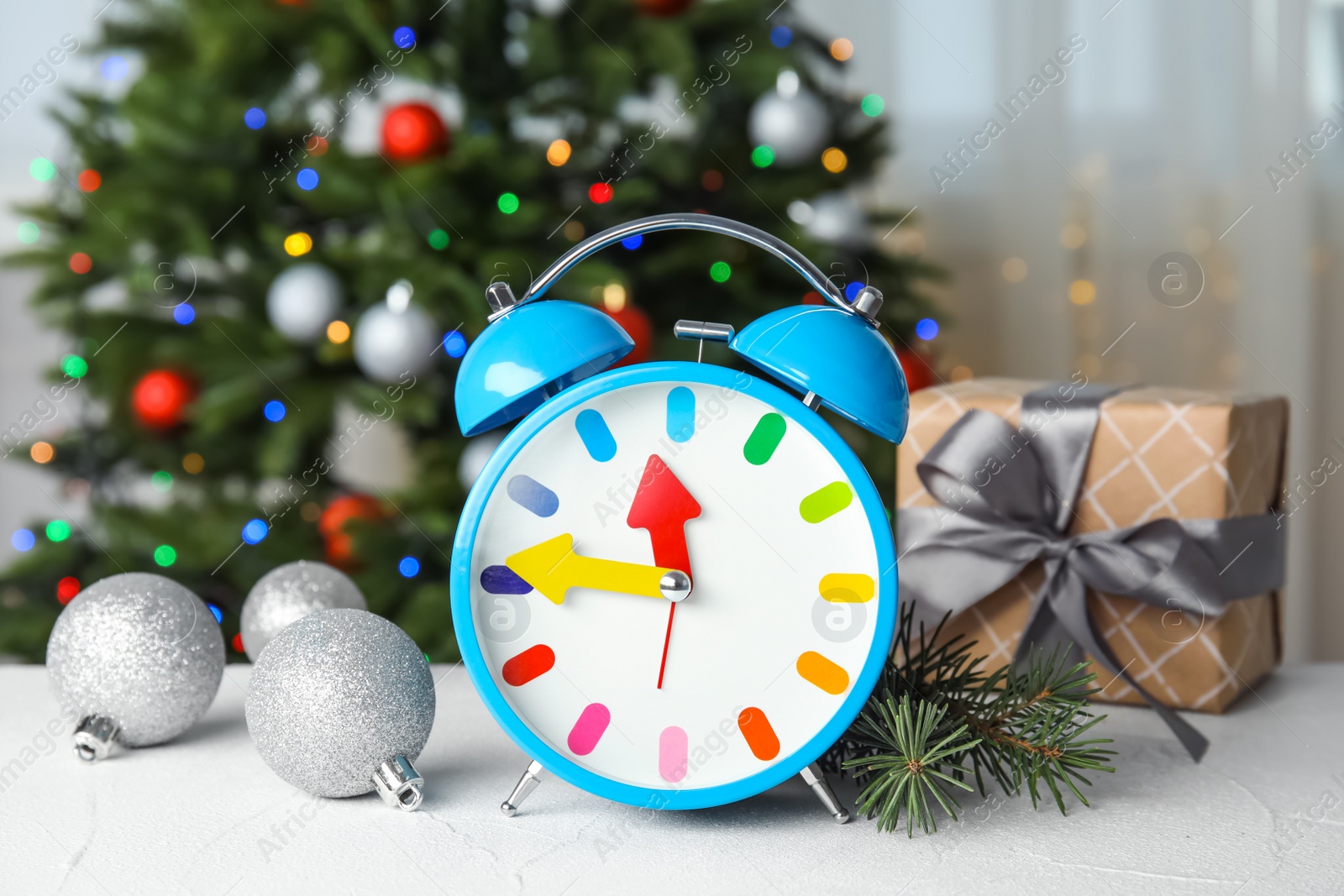 Photo of Retro alarm clock, gift and festive decor on table. Christmas countdown