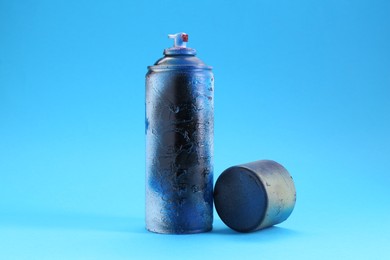 Photo of Spray paint can with cap on light blue background