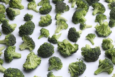 Photo of Many fresh green broccoli pieces on white background