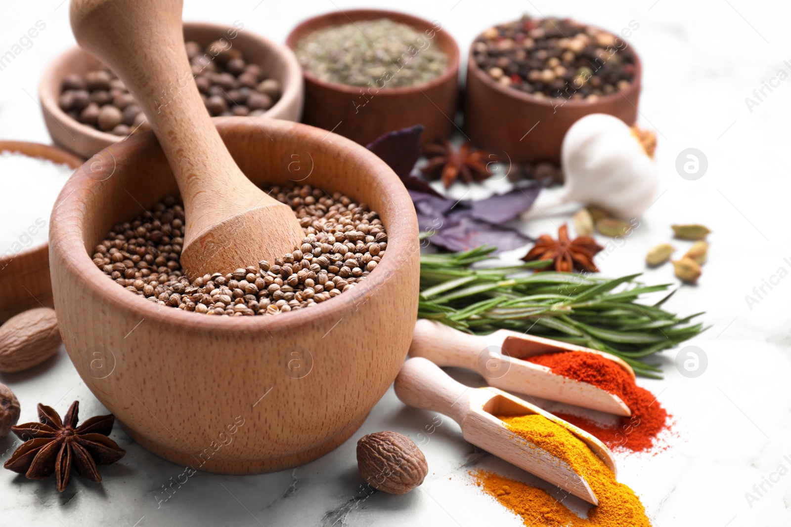 Photo of Mortar and spices on white marble table, closeup