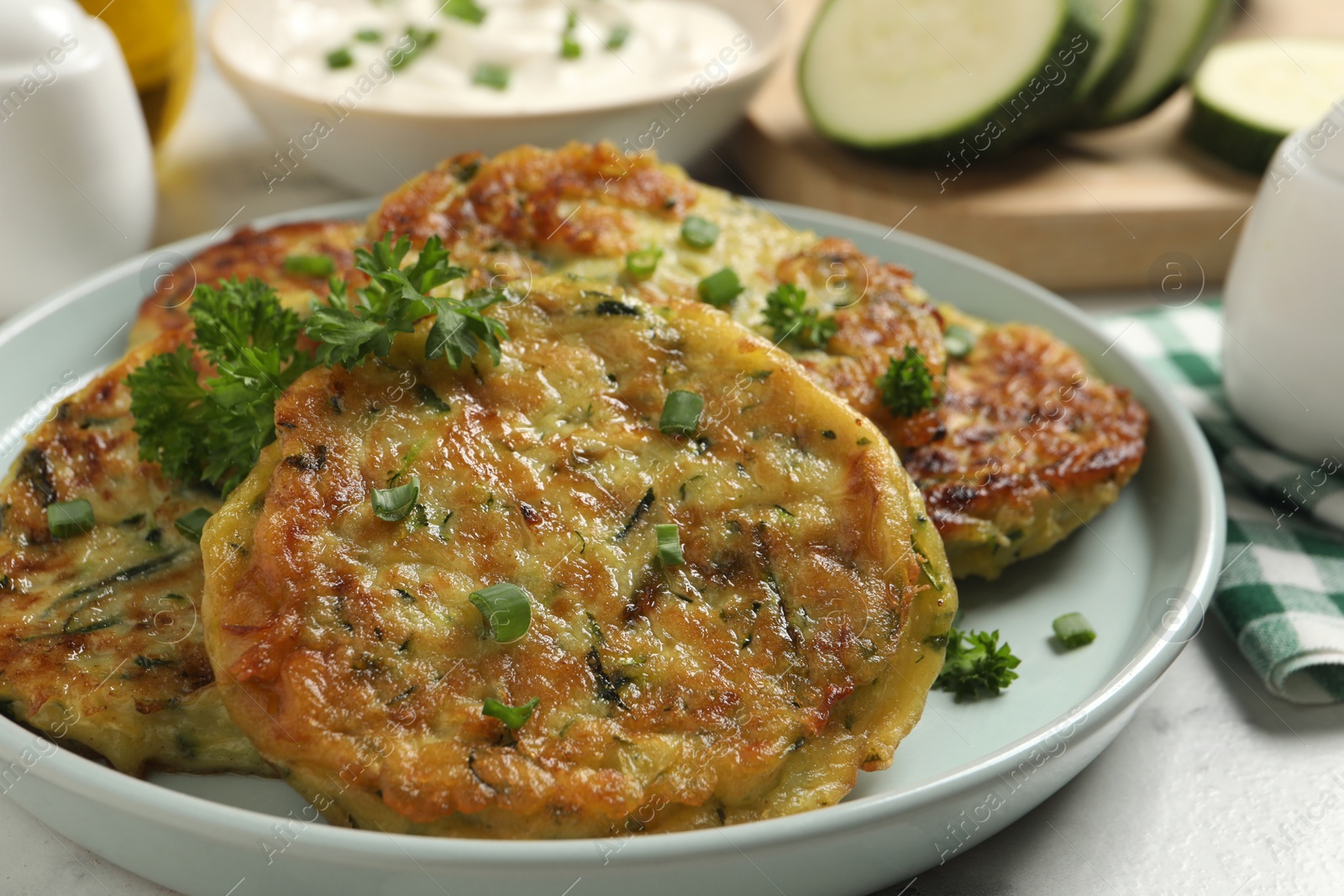 Photo of Delicious zucchini fritters served on table, closeup