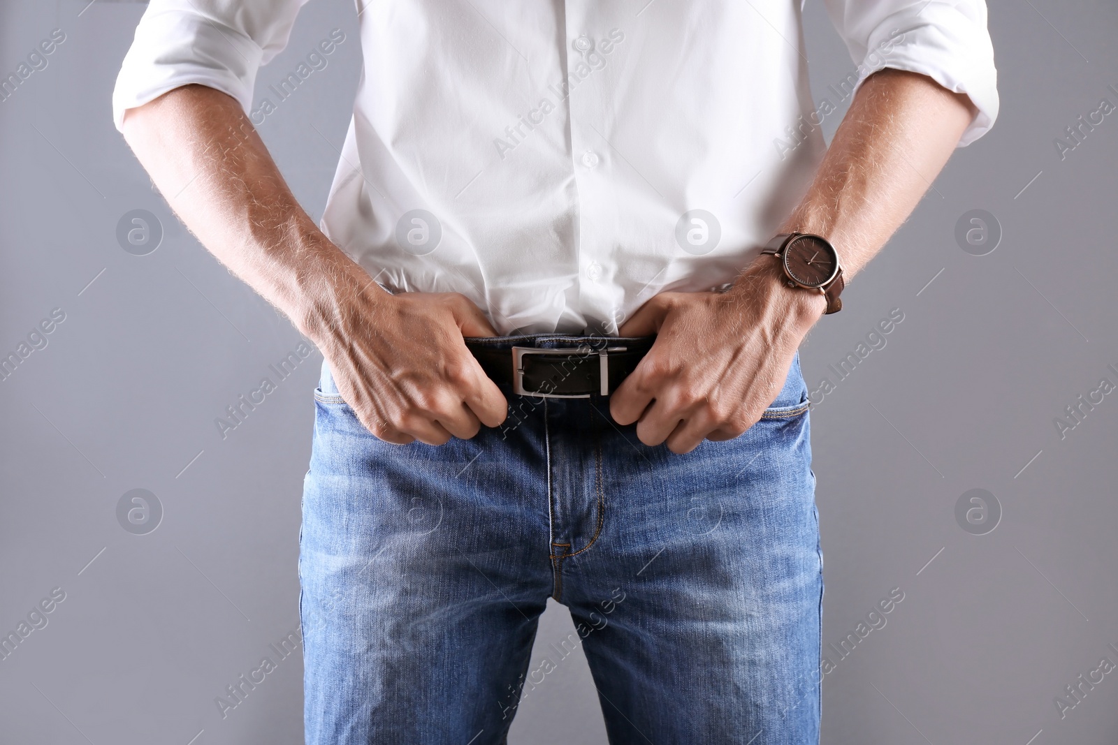 Photo of Man in stylish blue jeans on grey background