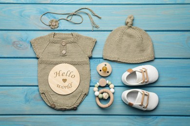 Photo of Flat lay composition with cute baby knitwear for photoshoot on light blue wooden background